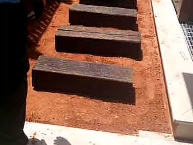garden-steps-railway-sleepers מדרגות מאדני רכבת על מצע אדמה בשלב הכנת השטח בגינה