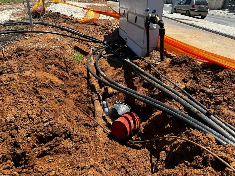 צנרת השקיה ומגופים בתעלה פתוחה ליד ארון השקיה בשטח פתוח צנרת השקיה ומגופים בתעלה פתוחה ליד ארון השקיה בשטח פתוח