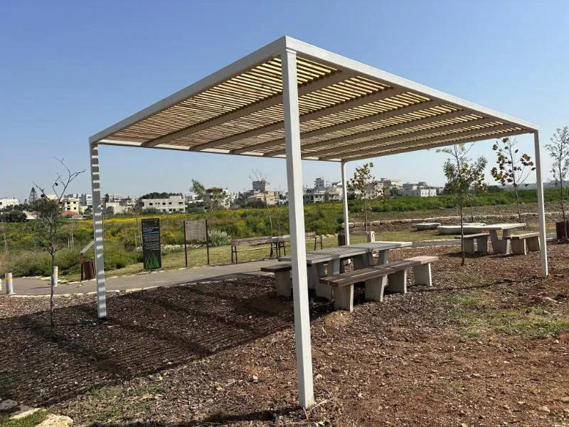 פרגולת הצללה עם שולחנות פיקניק בשטח המשוקם לאורך נחל קנה פרגולת הצללה עם שולחנות פיקניק בשטח המשוקם לאורך נחל קנה